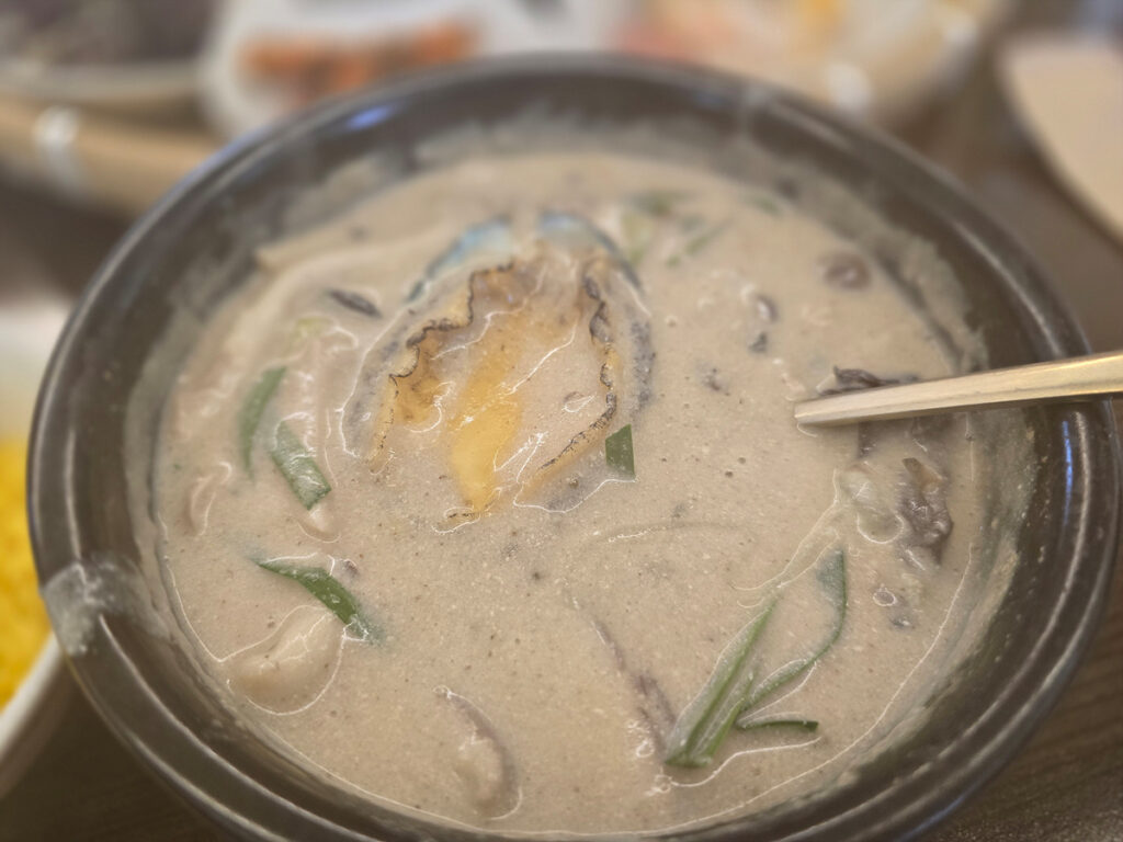 Close-up of abalone and mushroom perilla soup with a slice of abalone on top